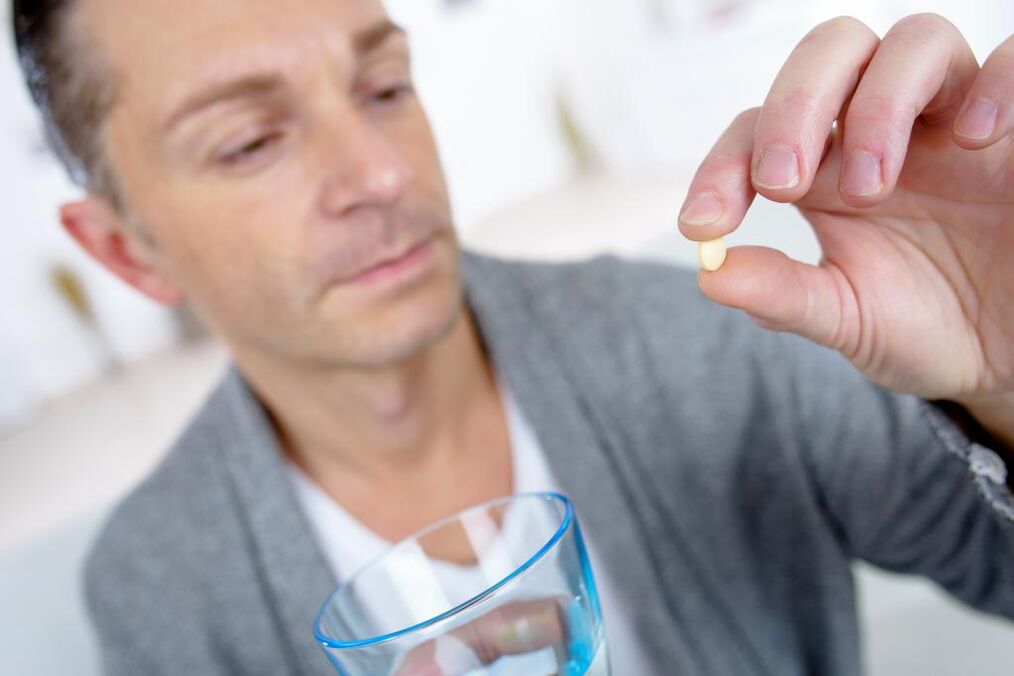 muž pije pilulku na zvýšenie potencie